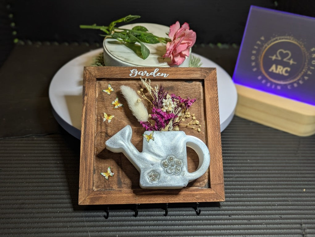 Hanging keys plaque with watering can with mauve flowers and butterfly's
